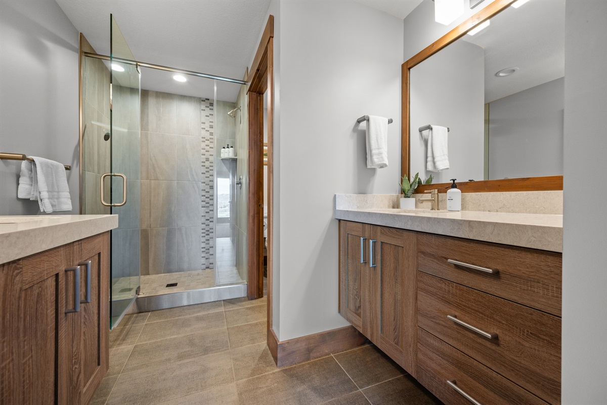 Spacious bathroom with walk-in glass shower and ample storage