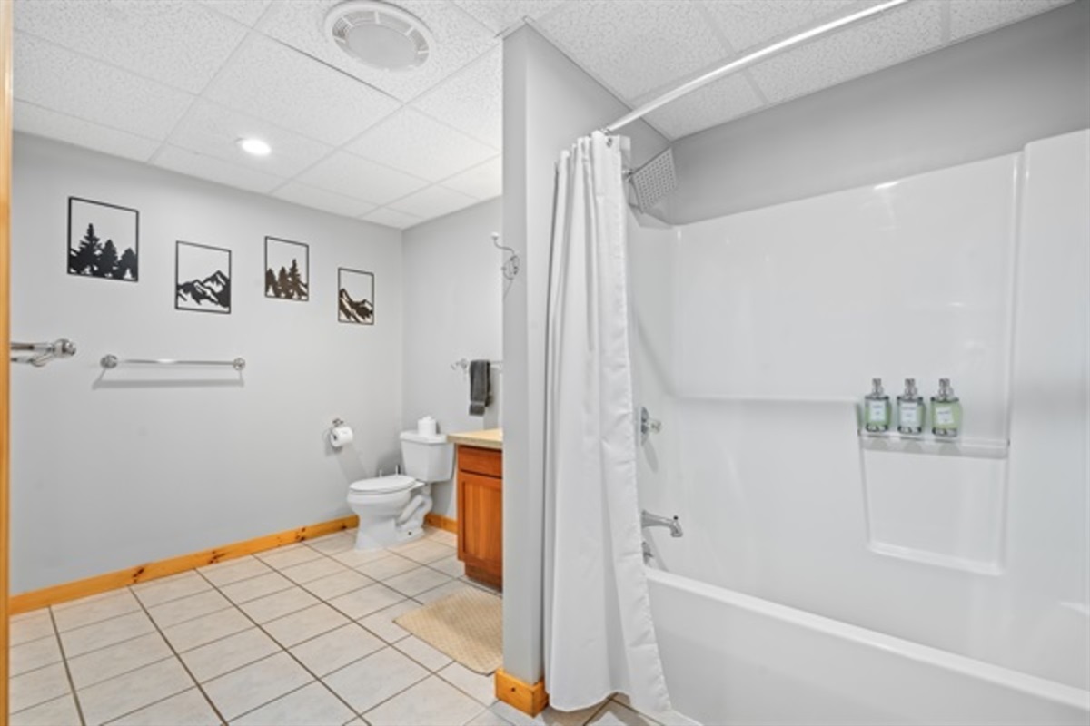 This spacious bathroom features a walk-in shower, warm wood accents, and a clean, calming design for a refreshing start or end to your day.