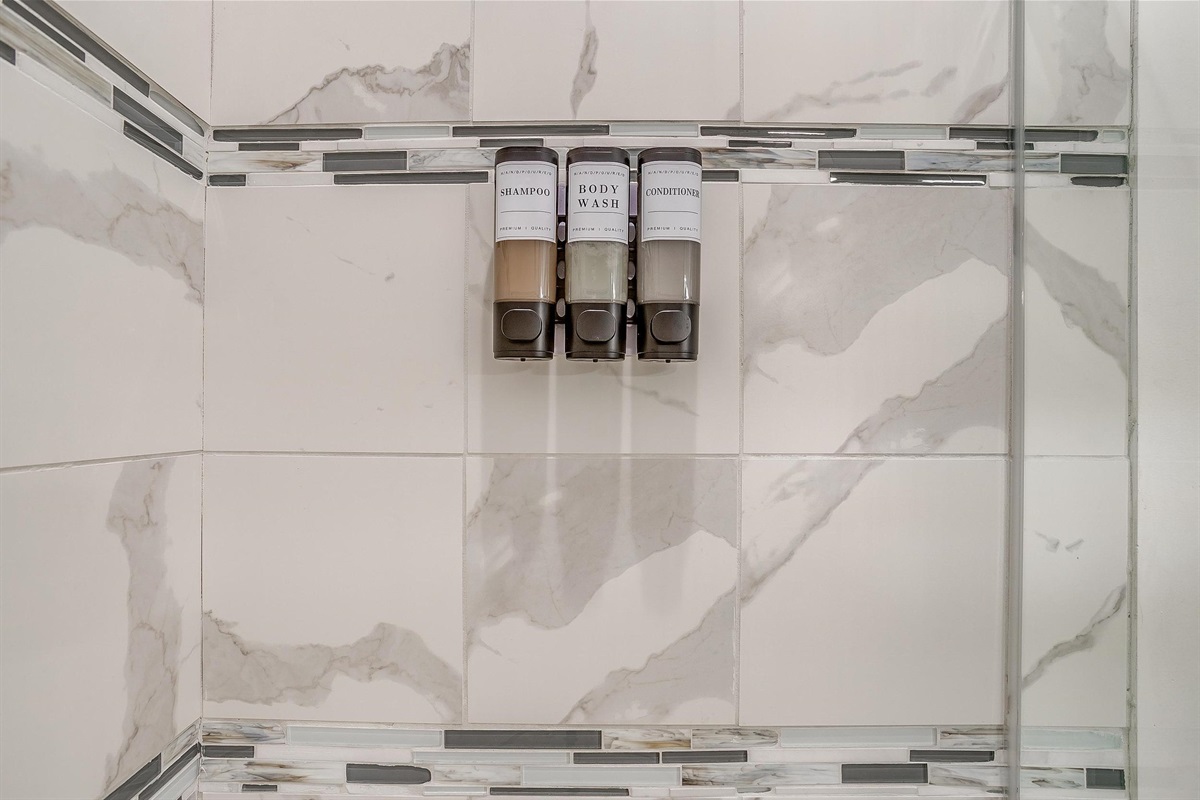Wall-mounted shampoo and body wash dispensers for your convenience.