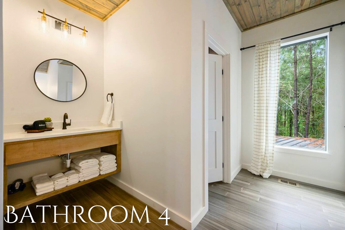 Conveniently located near the bunk room, this bathroom features modern fixtures and a clean, bright design.
