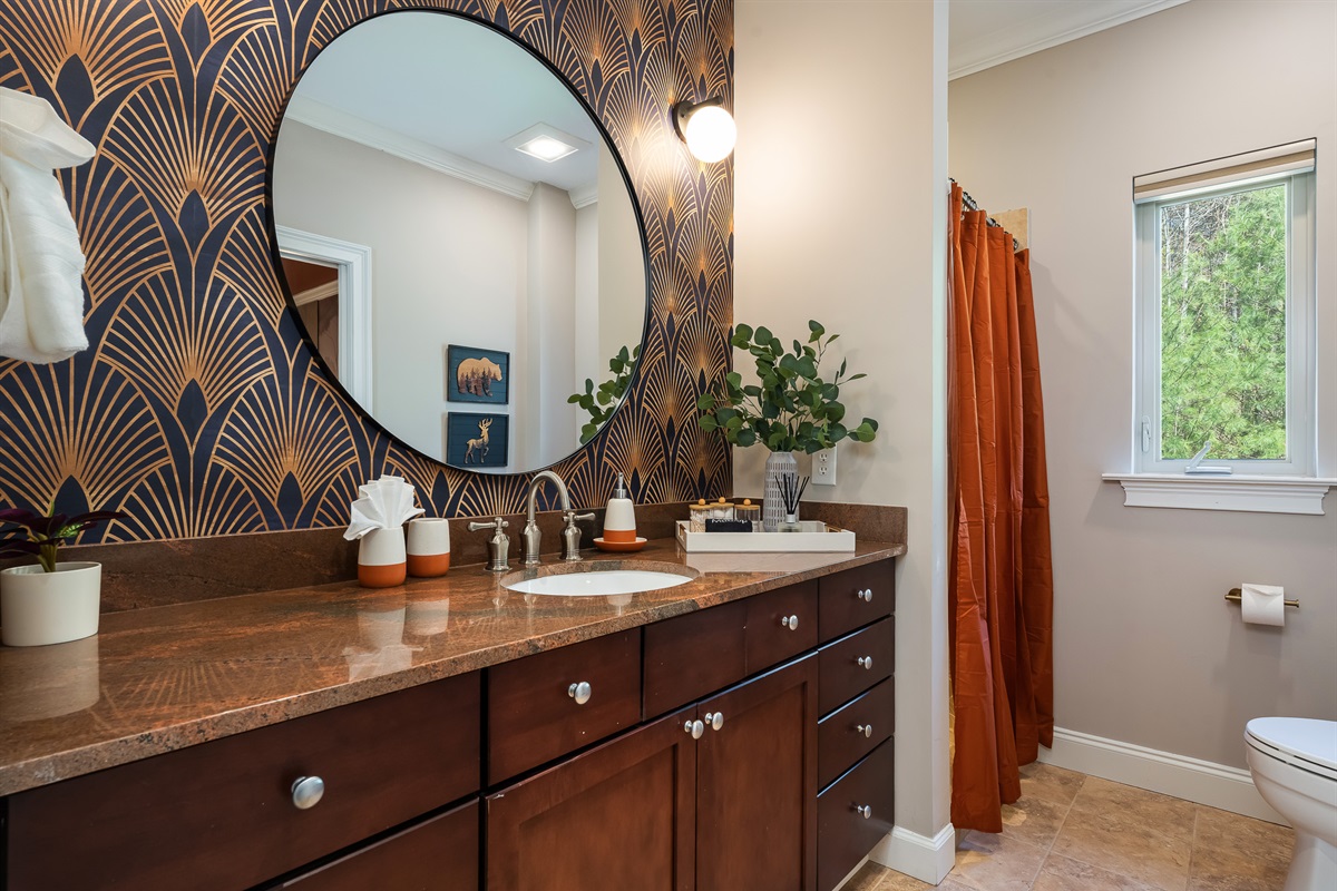Bathroom with statement mirror and custom vanity - design-forward details throughout the home