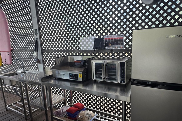 Refrigerator, griddle, air fryer, sink and counterspace in the Patio Kitchen