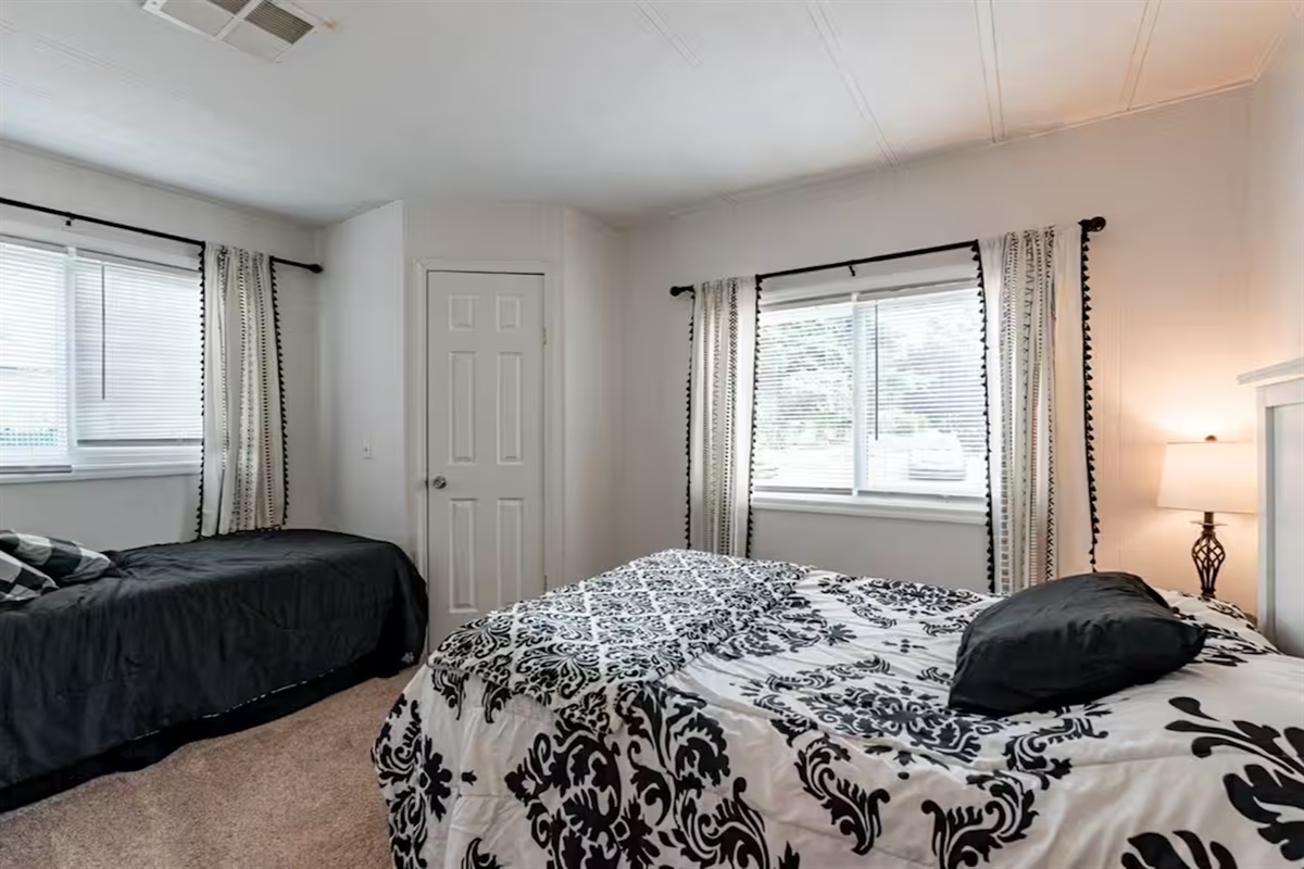 Bedroom two features one full-size and one twin bed, filled with natural light.