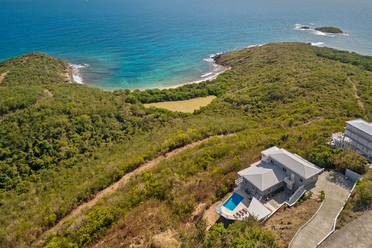 Breathtaking aerial views of the villa nestled in lush island greenery.