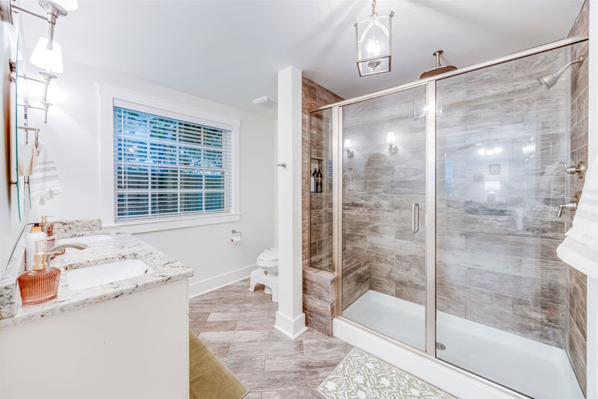 Spacious shower area paired with a sleek toilet, creating a functional and comfortable bathroom setup.