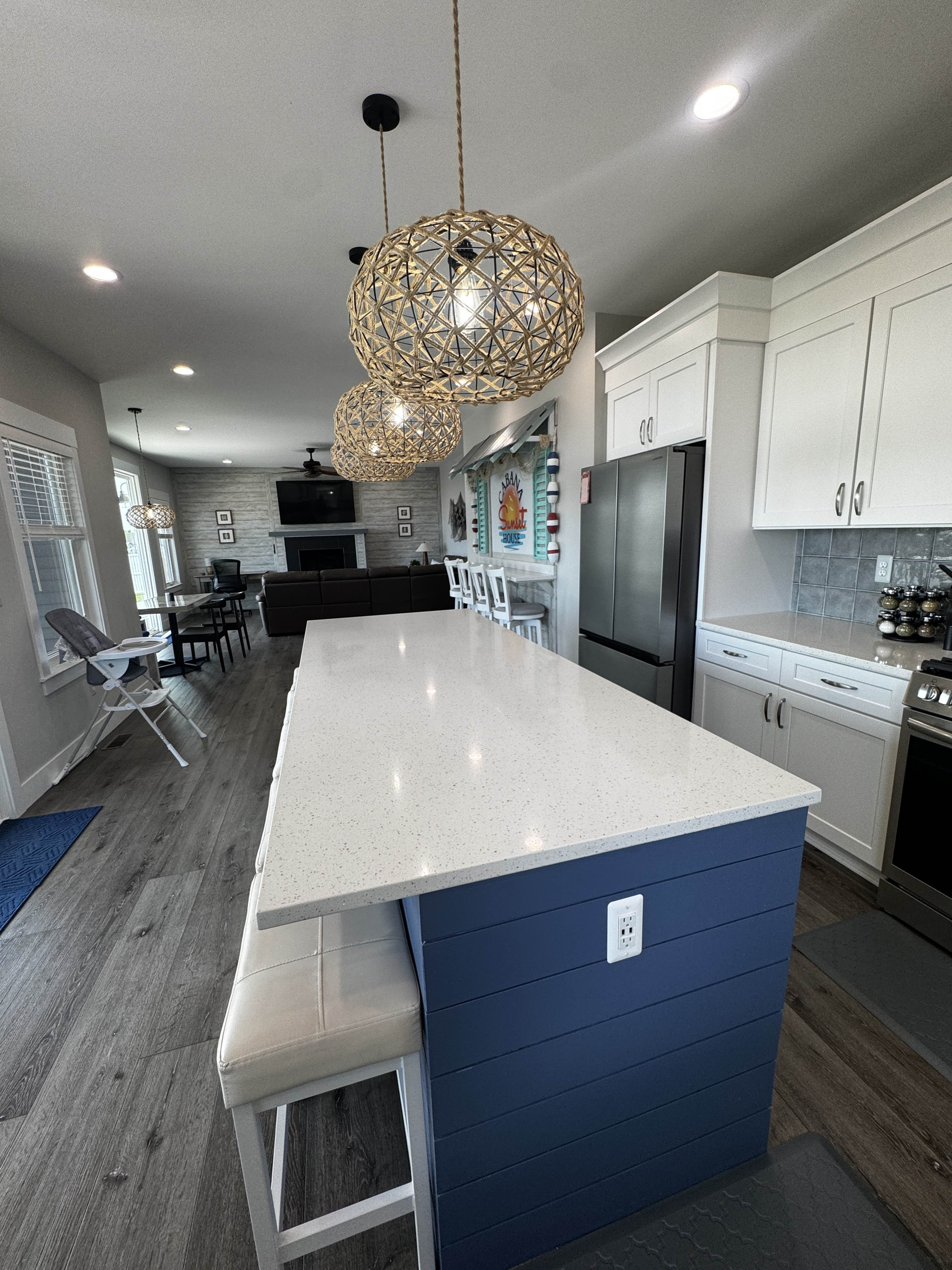 Modern kitchen with a large island, stylish pendant lighting, stainless steel appliances, and open layout flowing into the living and dining areas—perfect for cooking, dining, and entertaining.