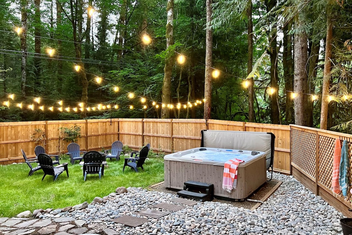 Gated side yard with privacy fence, hot tub and seasonal firepit.