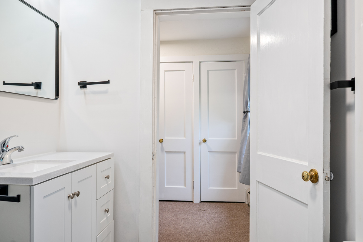 Enjoy plenty of space for extra linens and travel gear. This view looking out from the upper full bathroom highlights the large three-door closet built right into the landing, keeping essential storage easily accessible to the entire floor.