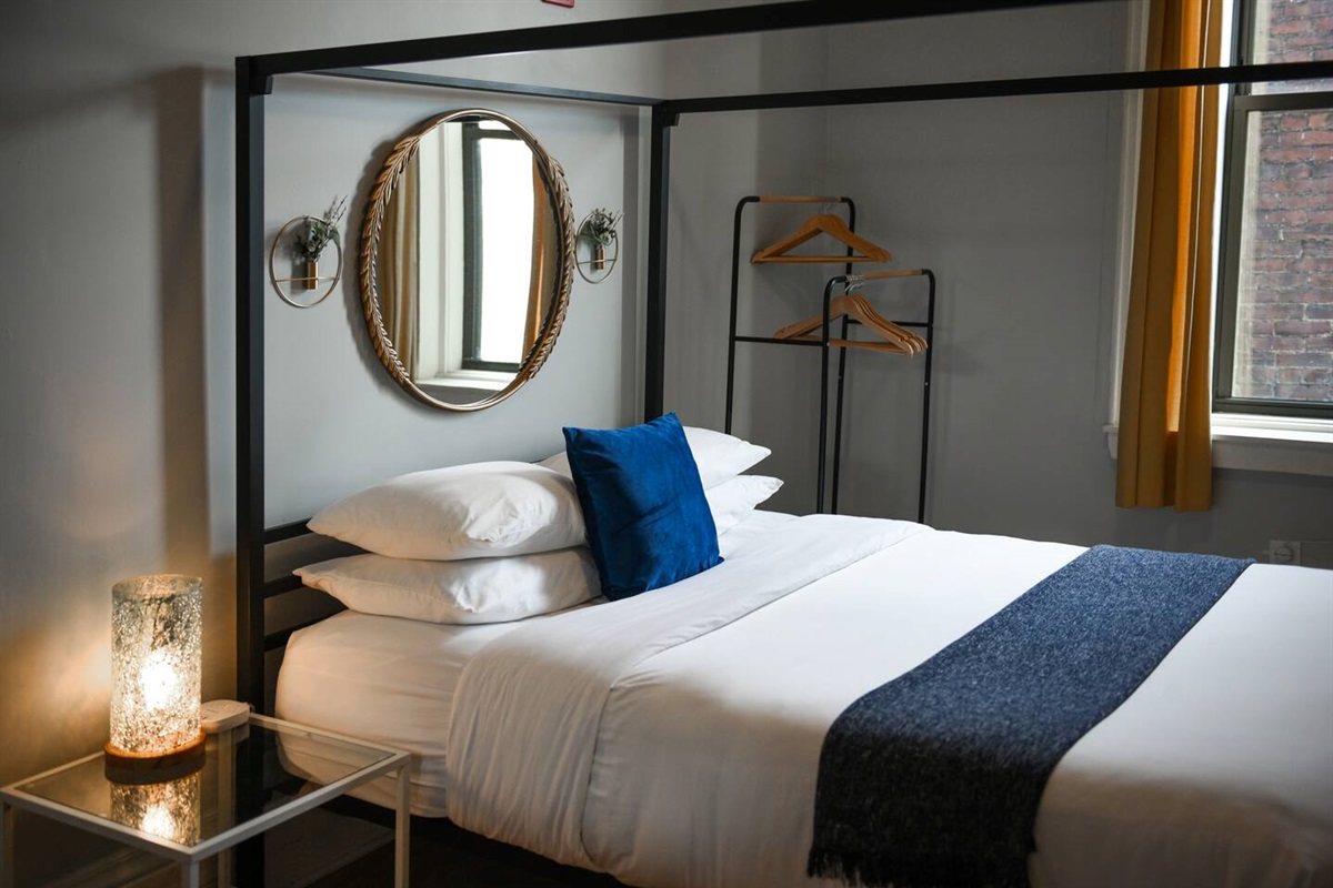 Cozy queen-sized bed with a unique frame and a TV for laid-back movie nights.