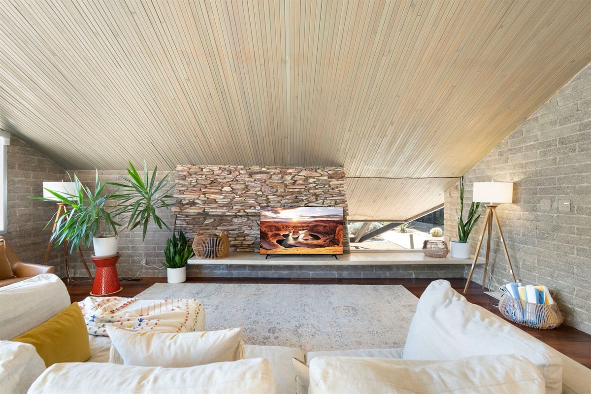 Stunning stone accent wall, vaulted wood ceilings, and a cozy lounge space designed for relaxing nights in.