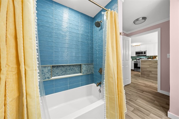 New in 2026 Kohler tub with glass tile surround & champagne gold delta fixtures