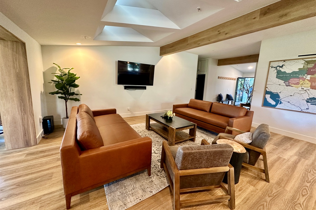 Expansive living room featuring architectural skylights, with a bright, social atmosphere.
