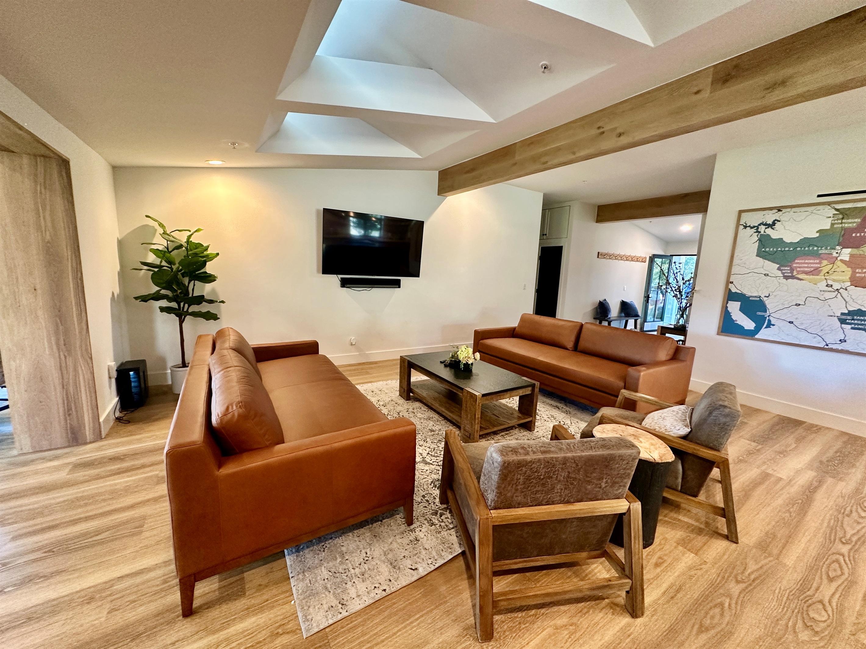 Expansive living room featuring architectural skylights, with a bright, social atmosphere.