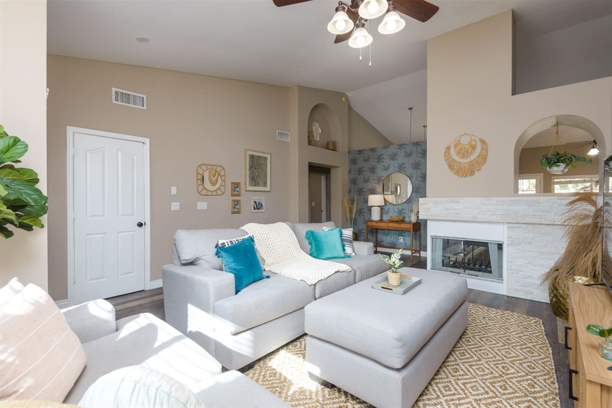 Living room with vaulted ceiling, large Smart TV, comfortable sectional seating, and room to relax or gather indoors.