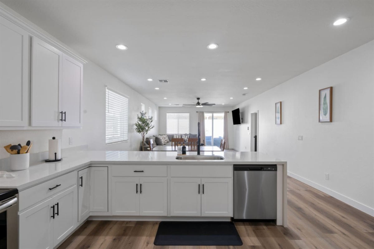 Full kitchen with stainless steel appliances, white cabinetry, dishwasher, and plenty of counter space for everyday meals.
