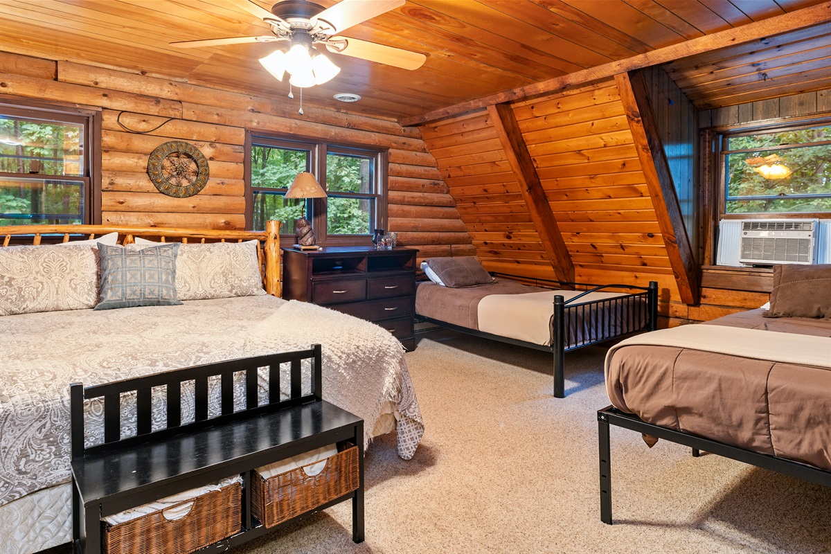 Bedroom #4 Inviting bedroom with a King, 2 double beds and an additional twin, rustic wood walls, and a comfortable, homey atmosphere.