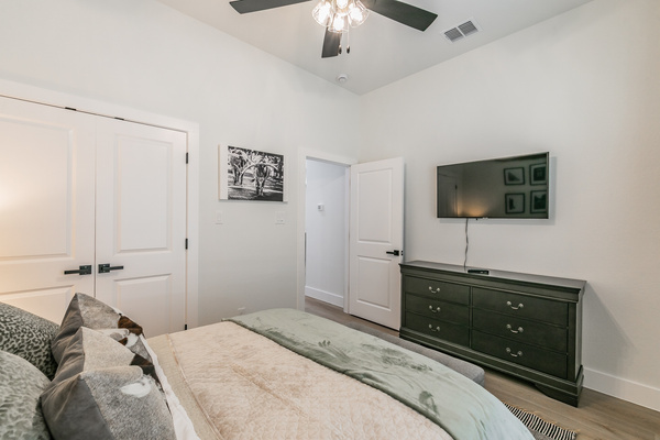 The Fort Worth Room with queen bed, smart TV, ceiling fan and clothing storage