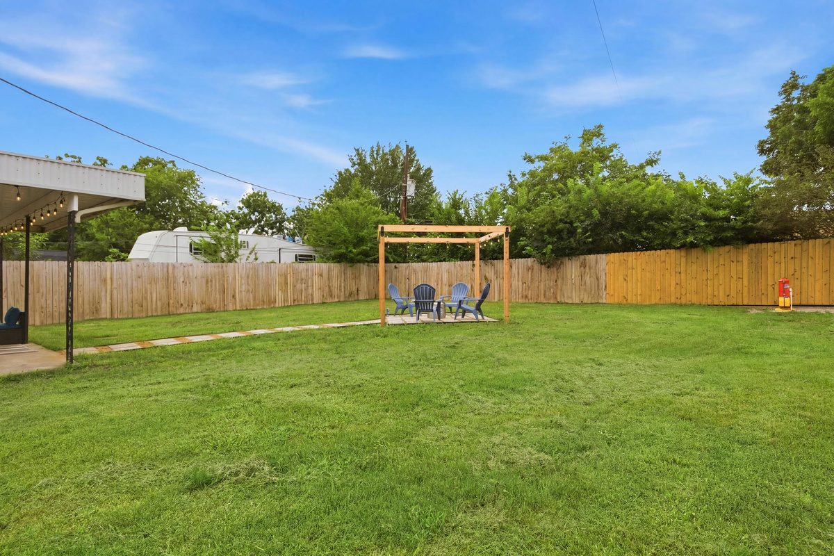 Fully Fenced Backyard with manicured lawn, Pergola seating, and Fire Pit area. Perfect for evening gatherings and game-day cookouts after a Cowboys or Rangers win at AT&T Stadium and Globe Life Field.