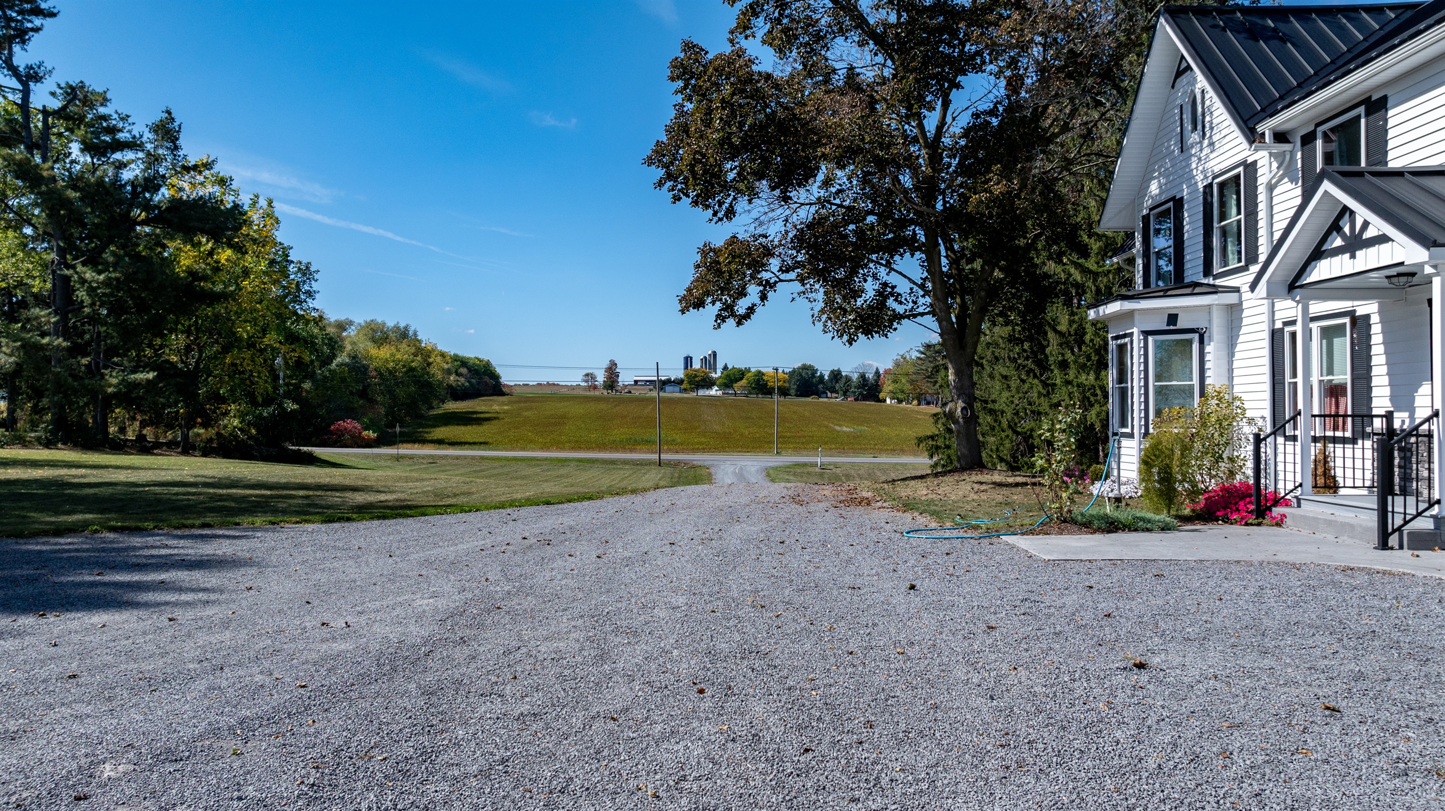 Peaceful driveway leading to open skies and lake views — welcome to your quiet country retreat