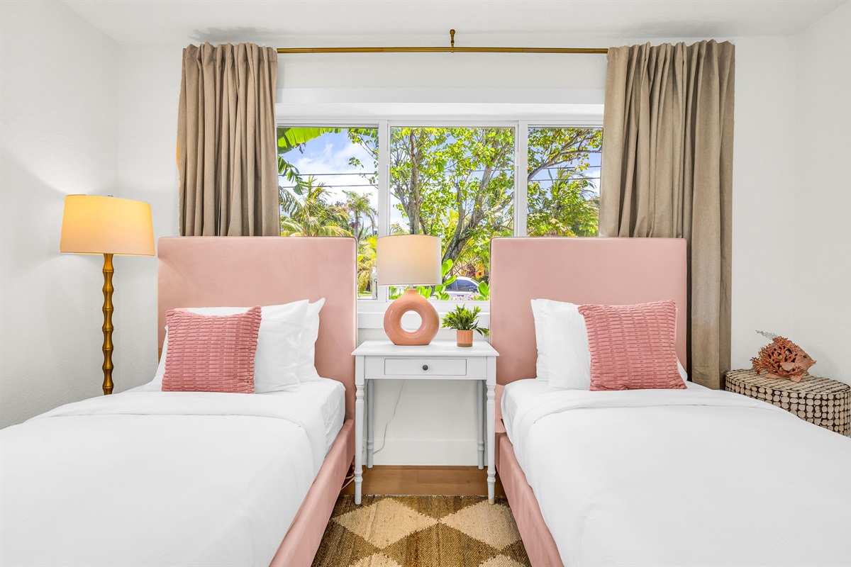 Chic and serene, this beautifully designed twin bedroom features plush velvet headboards, designer lighting, and abundant natural light with views of the lush tropical landscape—perfect for children or additional guests to unwind in refined comfort.