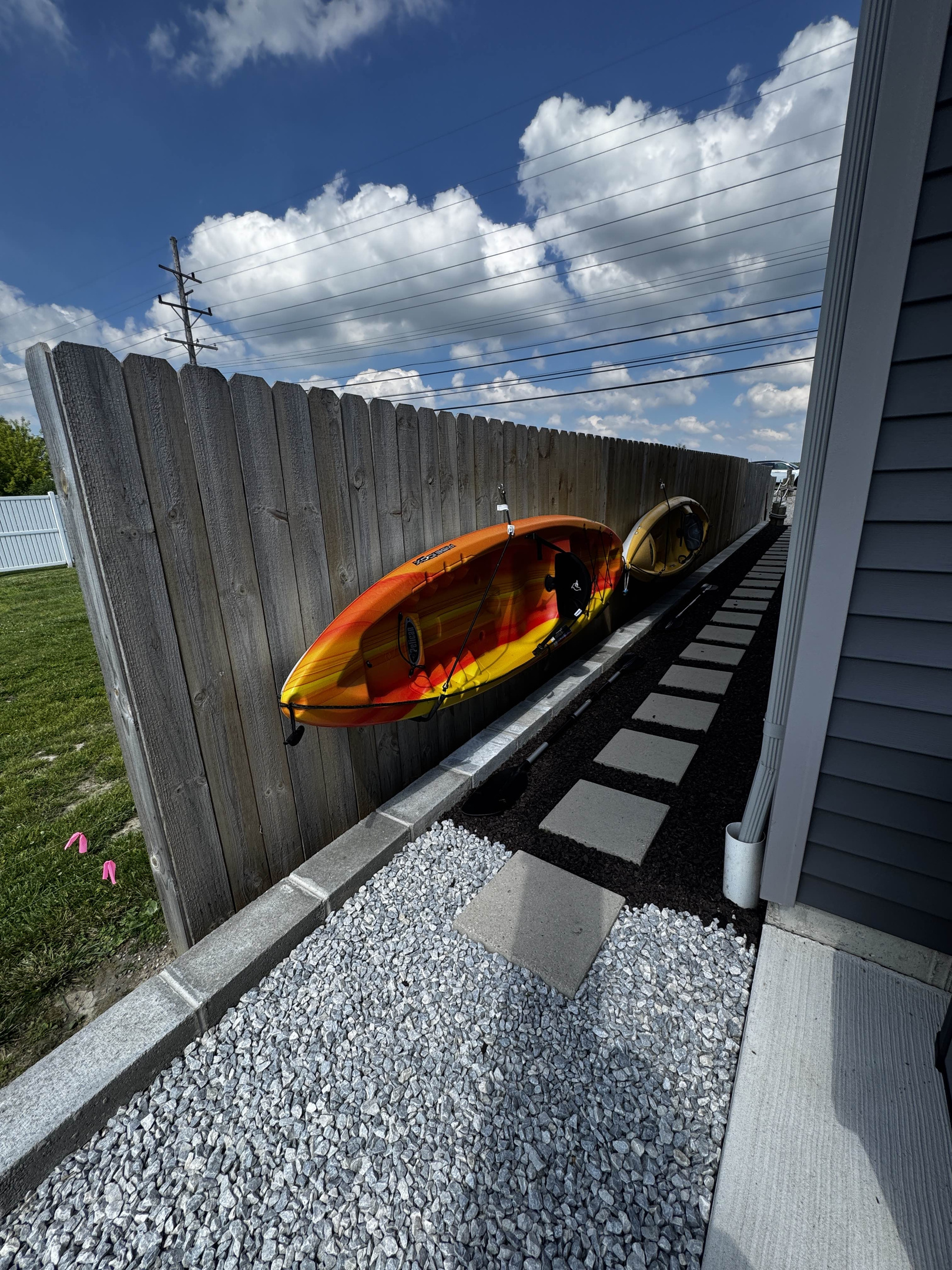 Clean side walkway with stepping stones and gravel path, connecting outdoor spaces along the waterfront home.