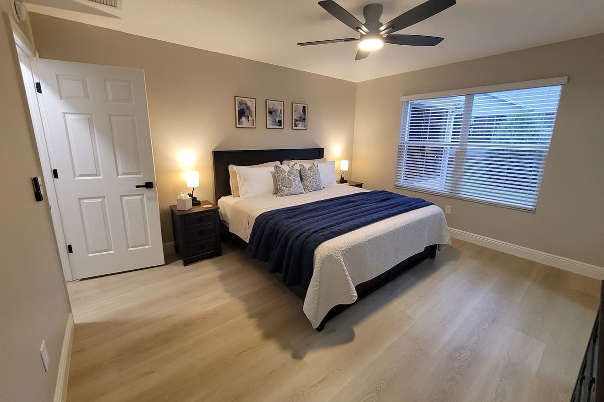 Retreat to the spacious primary king suite, featuring premium linens, bedside lighting, and a serene atmosphere designed for relaxation. The perfect place to unwind and recharge after a day of enjoying The Villages.
