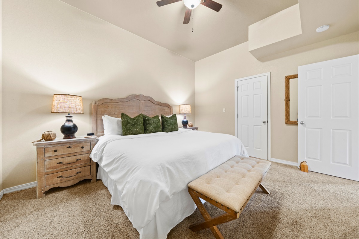 Soft bedding and gentle lighting make this king retreat an ideal place to unwind, offering a soothing spot to rest, read, or simply settle into the peaceful atmosphere.