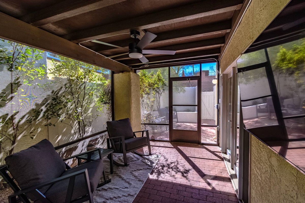 Fully screened in outdoor seating area with television. Access is through double-doors from the main kitchen area.