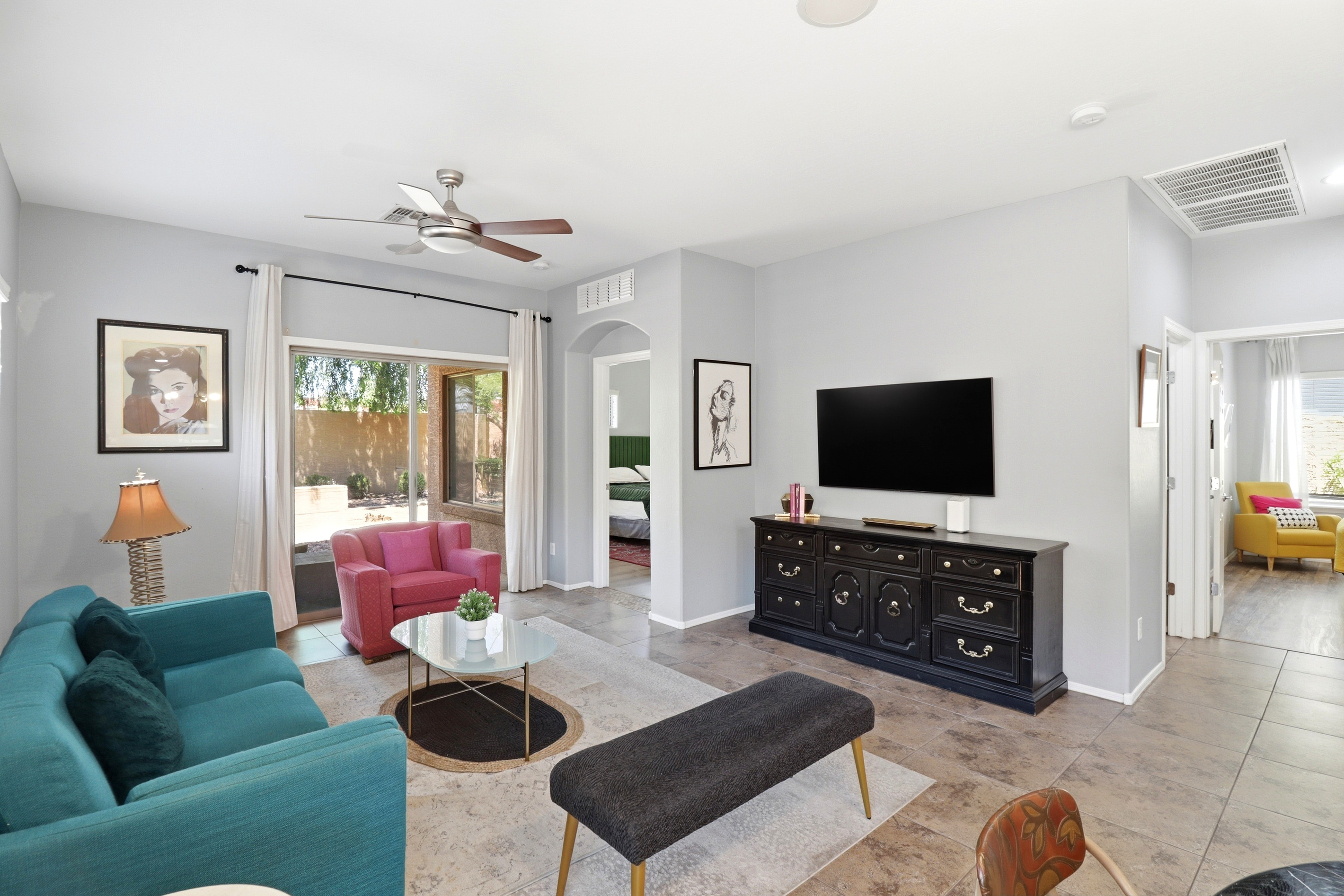Living room with colorful seating, a TV, and easy access to the patio and bedrooms.
