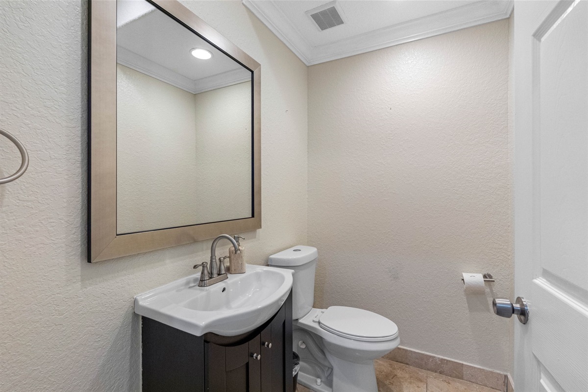 Perfect for quick visits or guest use, this half bath includes a toilet and vanity with sink, providing convenient access without compromising on style.