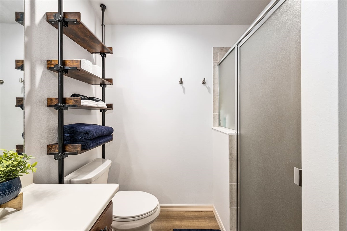 This bathroom features a standing shower and complimentary shampoo, conditioner, and body wash.