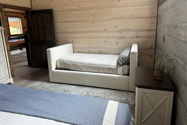 Nestled in the same room as the queen bed, this single bed offers a comfortable and private sleeping spot, ideal for kids or an extra guest.