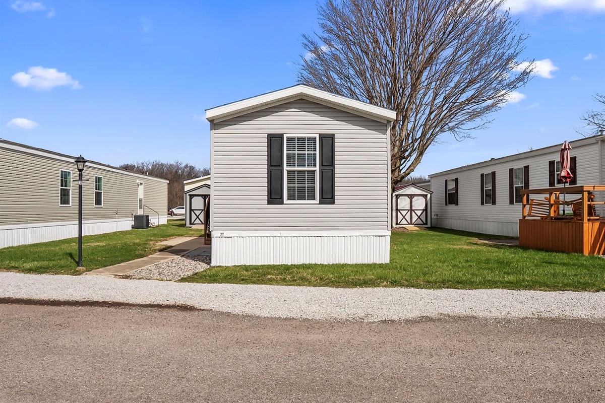 Front-facing view of the home with open surroundings and convenient parking nearby.