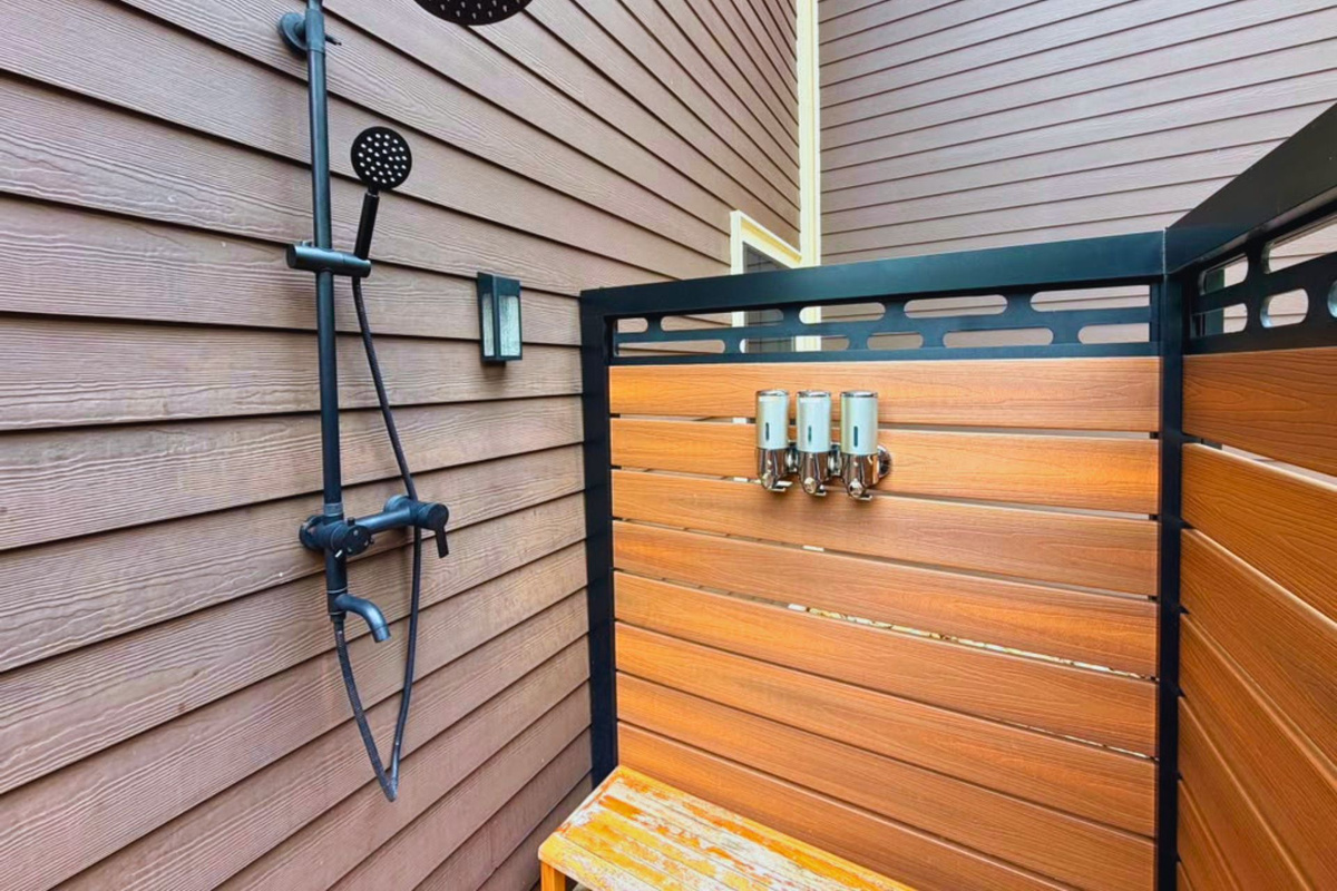 Experience a unique luxury amenity during your stay. The enclosed outdoor shower combines high-end matte fixtures with rustic wood siding, offering a beautiful, private place to unwind.