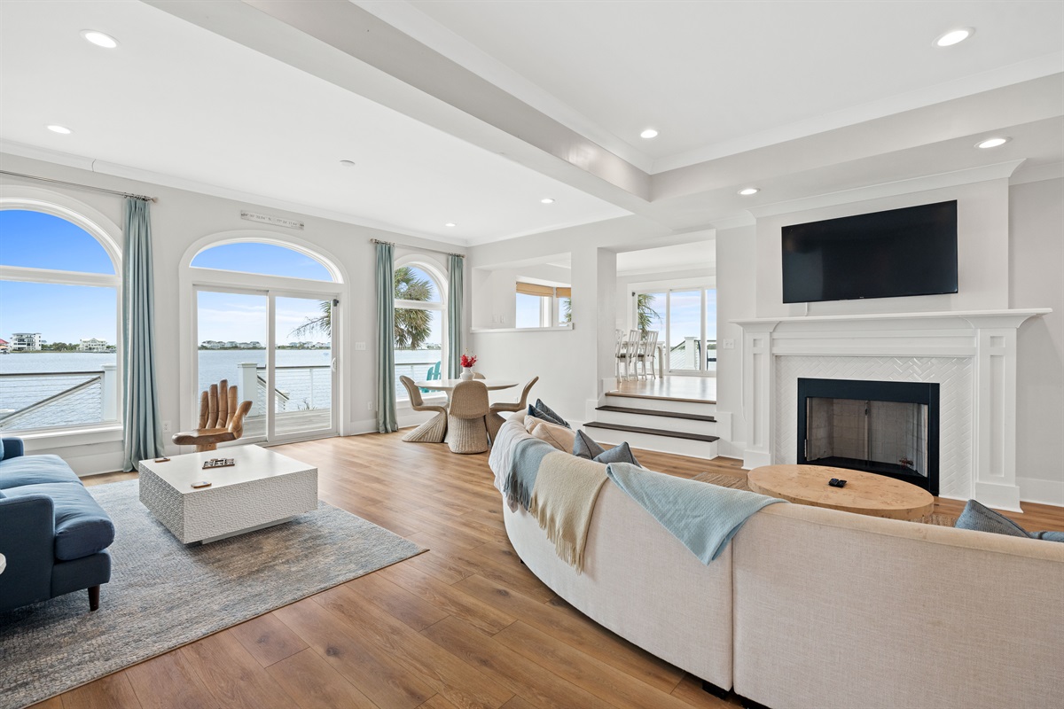 Spacious main level living room with panoramic views, elegant seating, and direct access to the deck for seamless indoor-outdoor relaxation