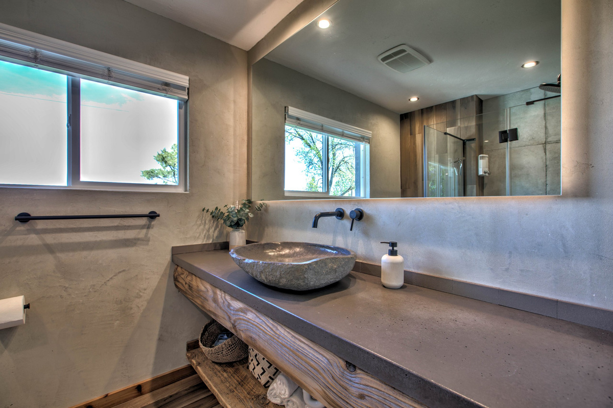 Spa-style bath with a stone vessel sink and reclaimed-wood vanity