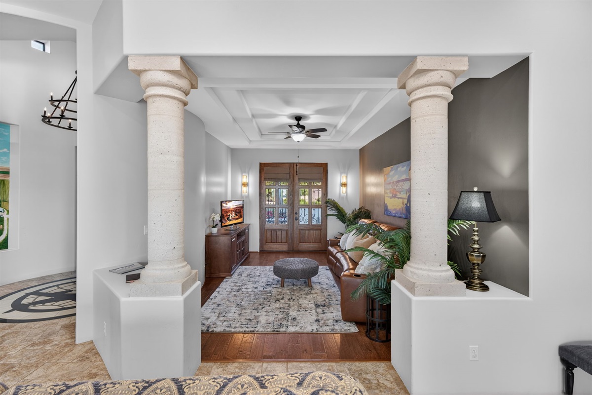Architectural hallway lounge with column detailing creates a quiet retreat space between the home’s gathering areas