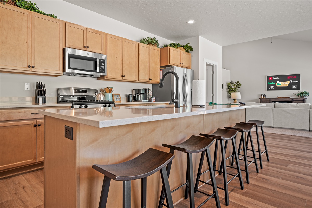 The spacious kitchen island seats five, creating the perfect spot to gather, chat, and watch the chef in action.