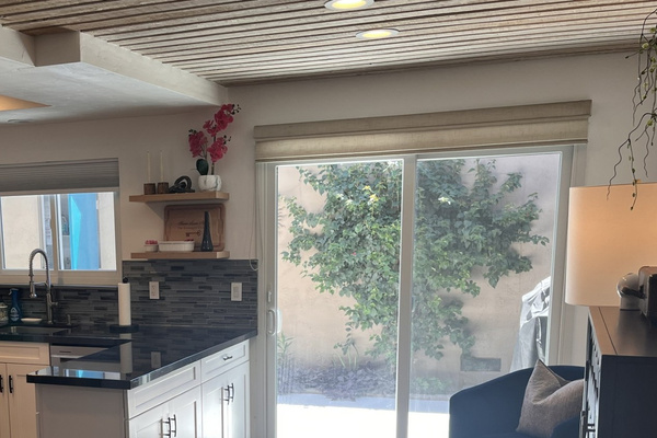 Lounge area includes dry bar and easy access to the courtyard with outdoor table and gas grill.
