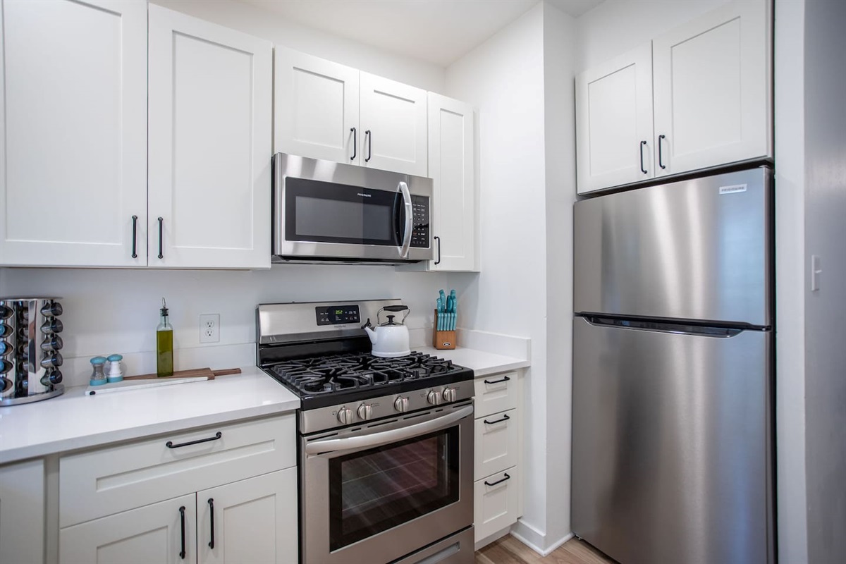 Fully equipped kitchen with modern appliances, including a stove, oven, refrigerator, microwave, and all the cookware and utensils needed to prepare delicious meals with ease.