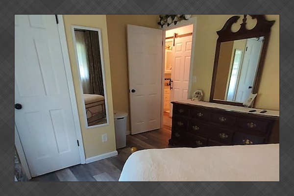 Both bedrooms offer privacy with their own lock and key. The cherry dresser provides generous drawer space, and the closet offers plenty of room for your belongings. A plush shag rug adds a cozy, welcoming touch underfoot.