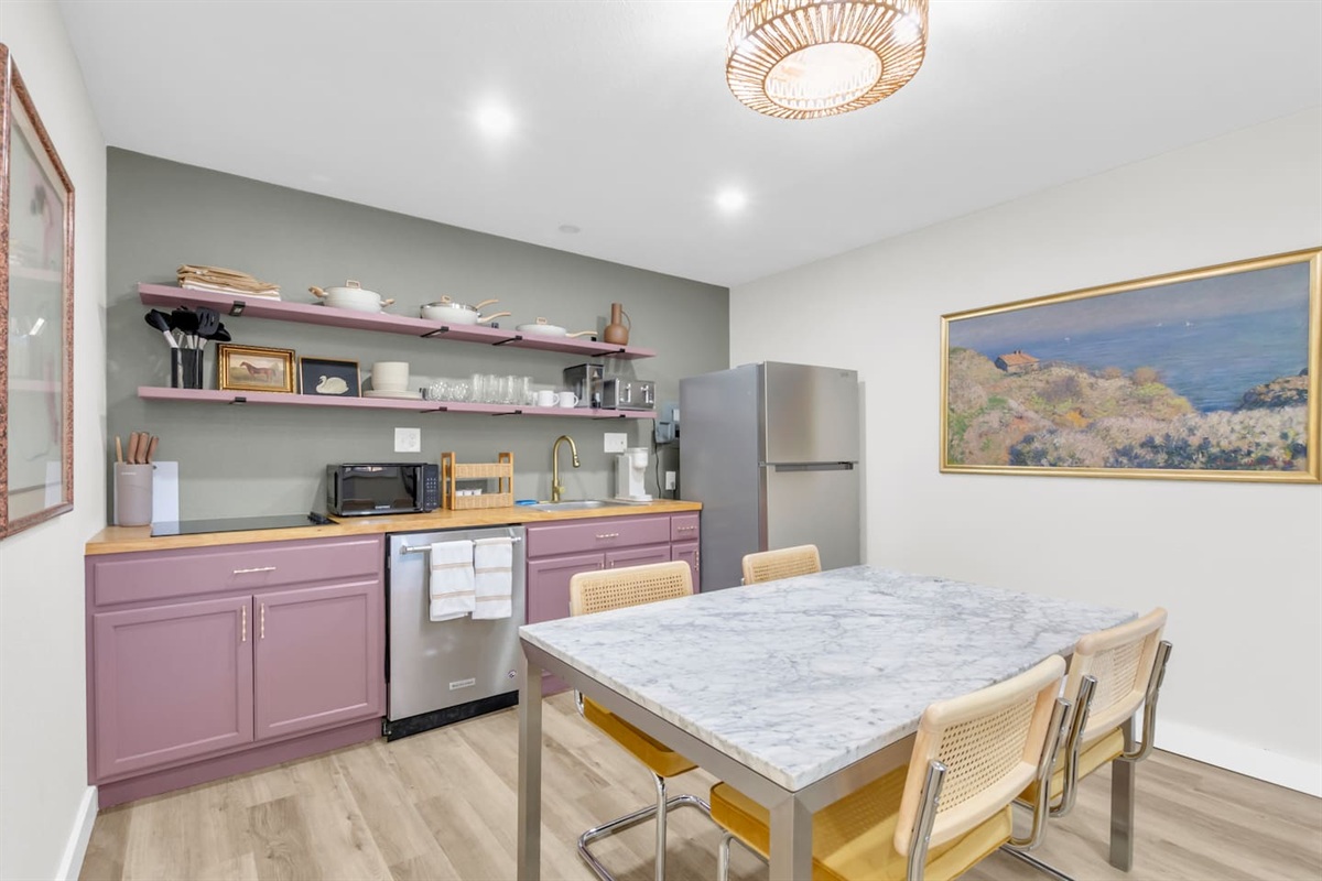 Stylish kitchen and dining area with seating for four; perfect for shared meals, morning coffee, or remote work in a modern Dallas setting.
