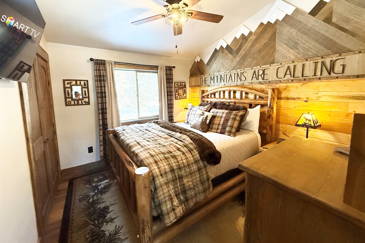Main floor bedroom | Queen bed. Equipped with a Smart TV, premium pillows/linens, room-darkening curtains, ceiling/window fans, charging stations, bedside lamps, extra blankets and pillows.