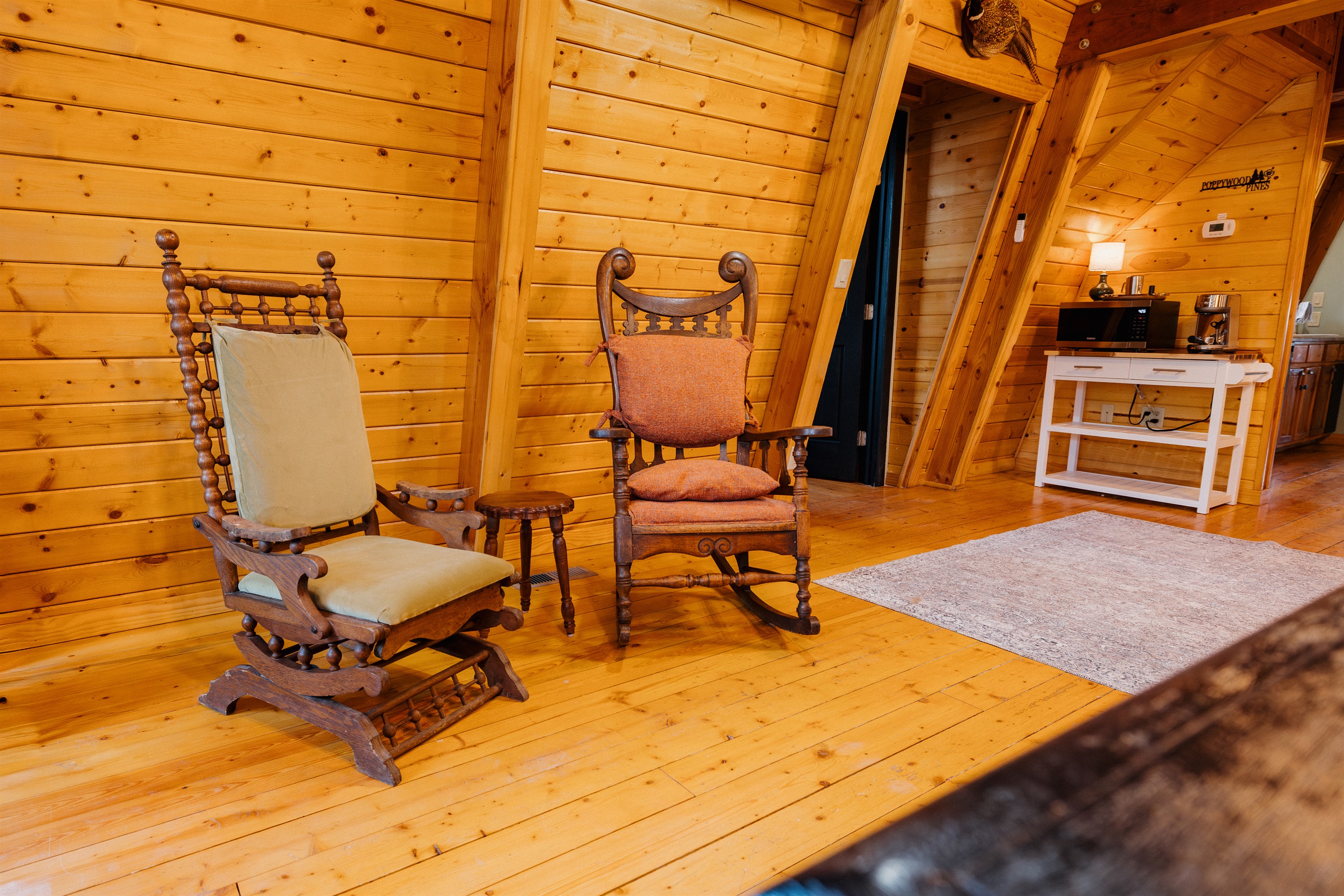 Poppywood Pines’ dining room is perfect for slow morning coffee and cozy evenings, featuring a dining table, vintage accent chairs, bar area, TV, and dog bed—an inviting, dog-friendly mountain cabin space for gathering in Arizona’s White Mountains.