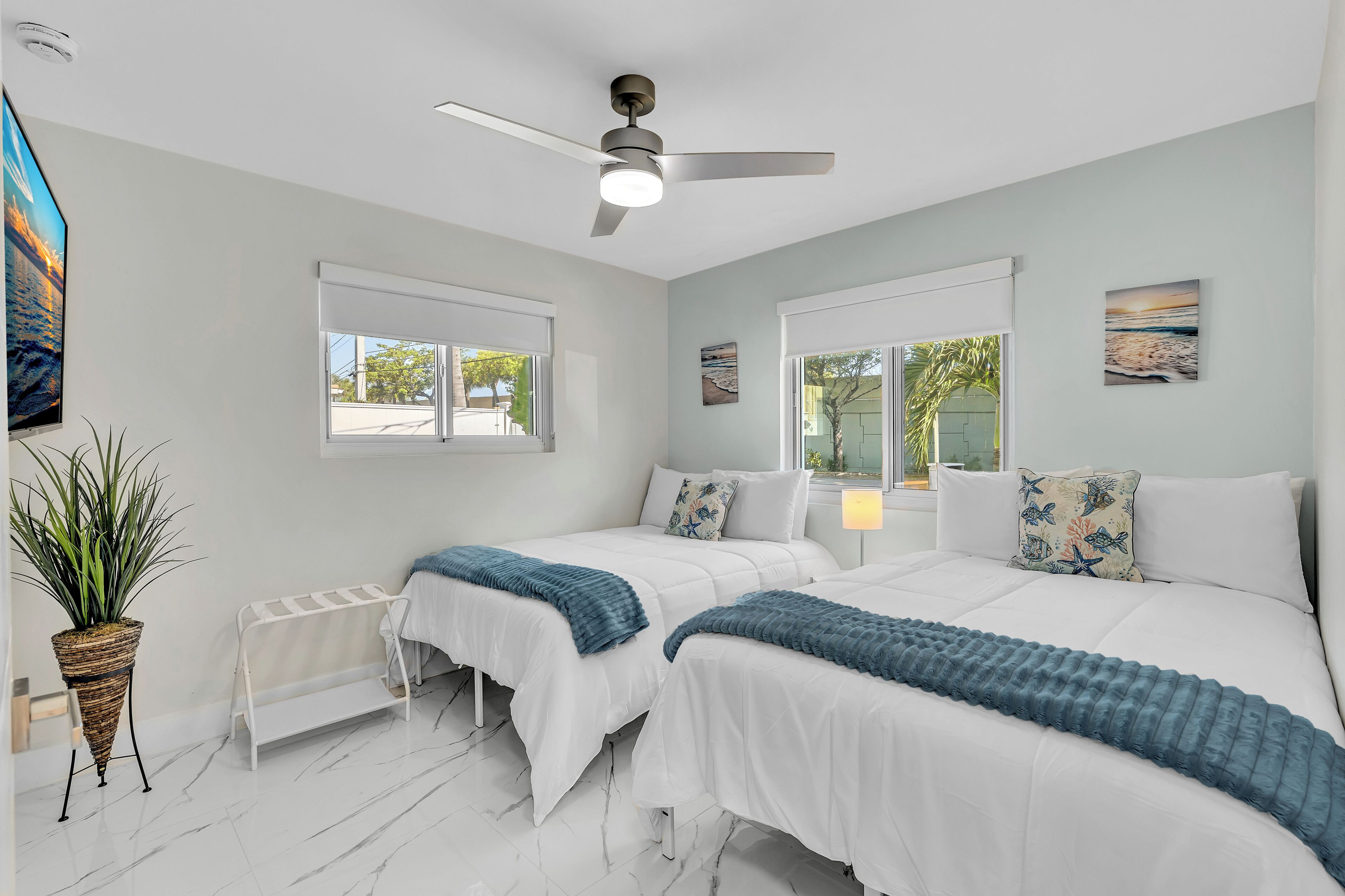 Bright bedroom with two full-size beds and plenty of natural light.
