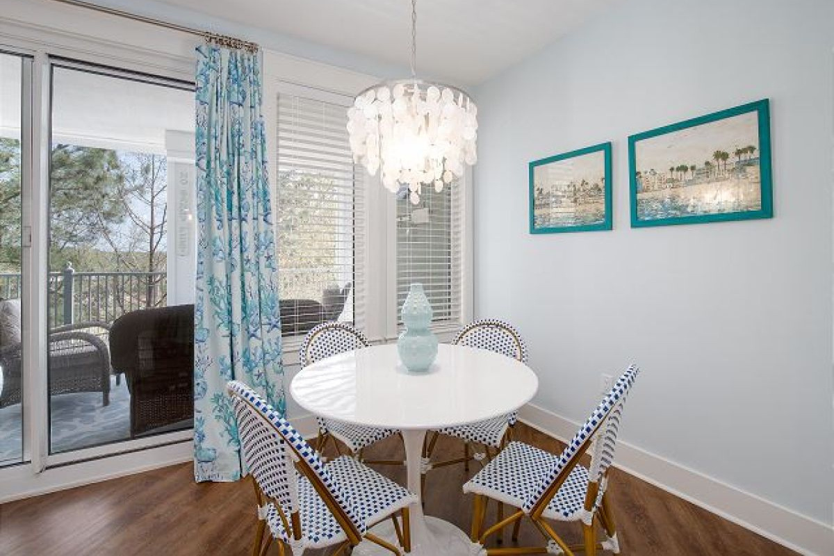 Dining table for four with capiz chandelier next to the sliding doors to the balcony
