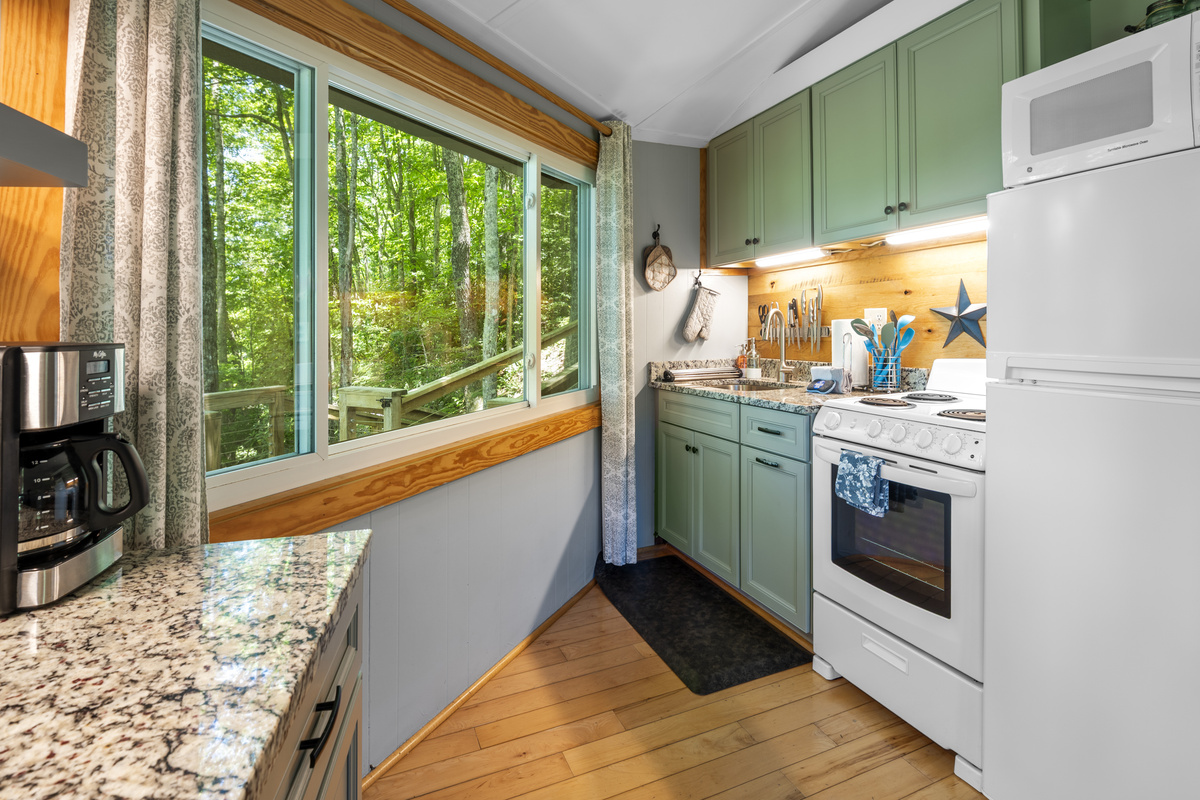 Stay in and prepare meals in this beautiful kitchen and enjoy the view. Updated kitchen with granite countertops, oven range, refrigerator, microwave. 