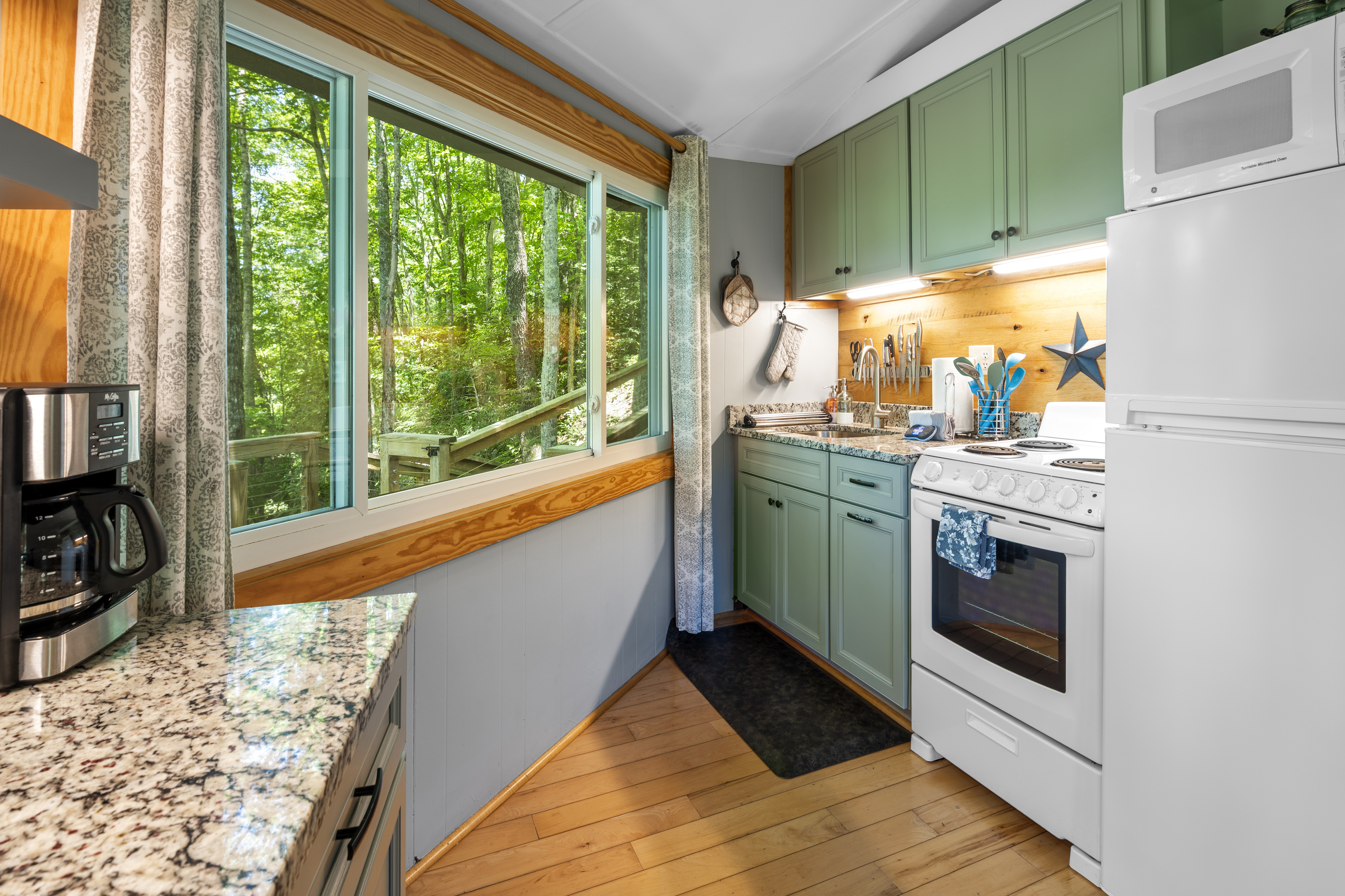 Stay in and prepare meals in this beautiful kitchen and enjoy the view. Updated kitchen with granite countertops, oven range, refrigerator, microwave. 