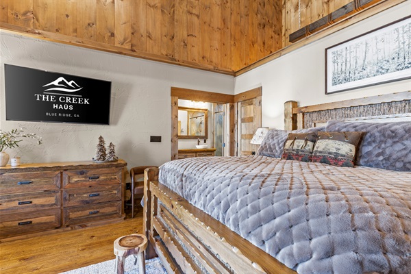Bedroom1: Unwind in the comforts of the master suite, featuring a luxurious king-sized bed, rustic charm, and warm wood accents for a cozy, inviting retreat.