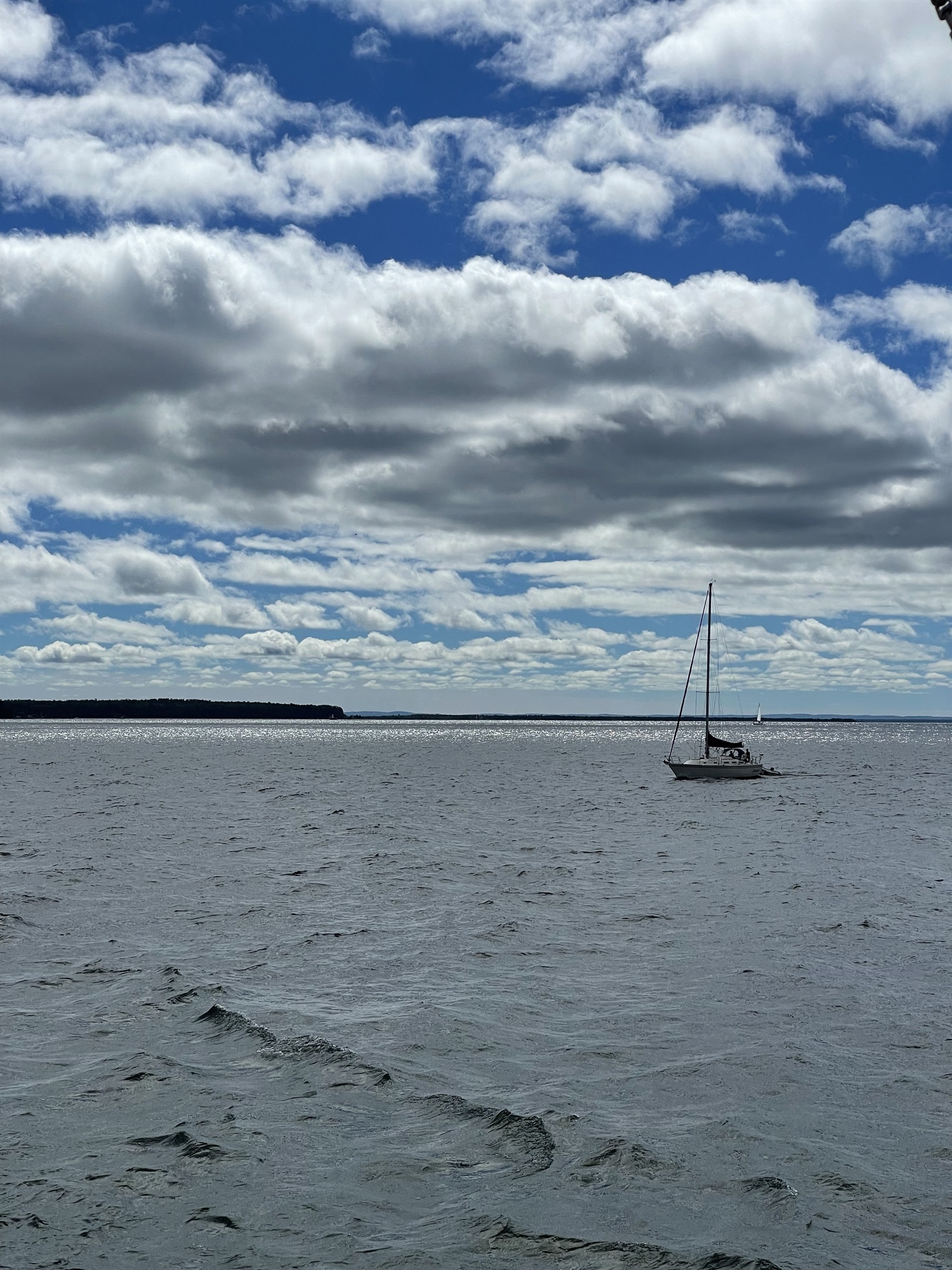 View towards Madeline Island from Bayfield docks - sailboat. Summer